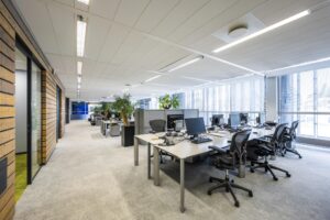 Modern open-plan office interior at Jacob Bontiusplaats with desks, office chairs, and large windows.